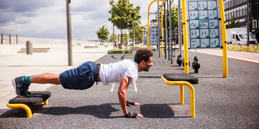 Een man doet een oefening in de fitnesszone op de Kaaien Een man doet een oefening in de fitnesszone op de Kaaien